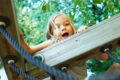 a young child climbing the wooden structure